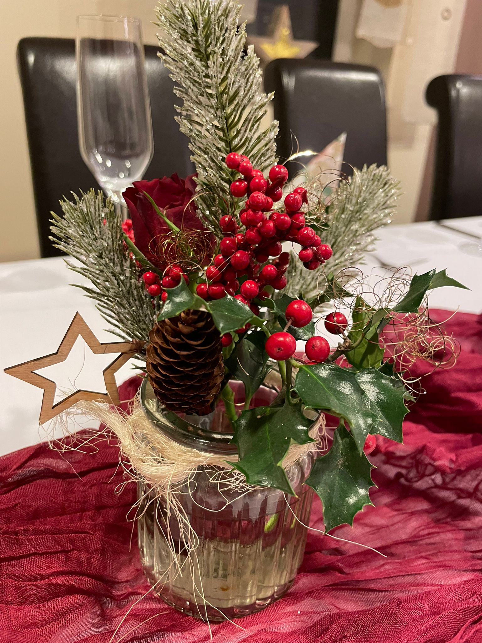 Weihnachtliche Tischdekoration mit Beeren und Zapfen